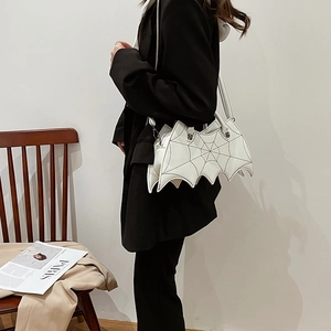Detail of white PU leather bat-shaped handbag with silver hardware and shoulder strap
