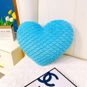 Détail d'un coussin en peluche en forme de cœur bleu ciel avec texture velours douce