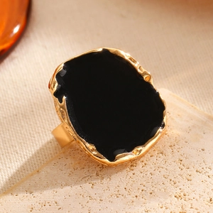 Macro detail of retro golden wide band ring with black enamel irregular oval stone