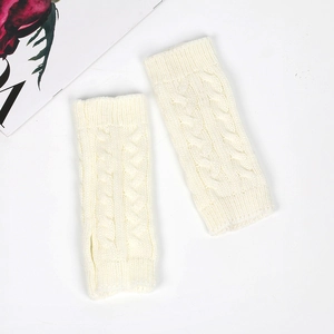 Close-up of beige cable knit fingerless gloves with thumb hole on white background