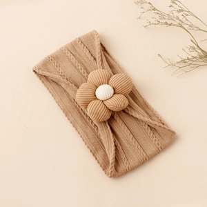 Detail of baby nylon headband featuring a large 3D fabric flower and wavy knit texture