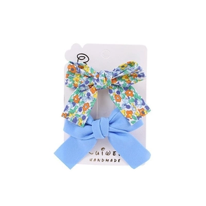 Two-piece floral and blue fabric bow hair clips for girls on white card