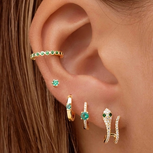 Detail of S925 silver gold earrings set with emerald stones and zircon micro-pave