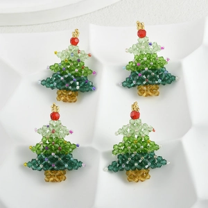 Macro shot of green crystal beaded Christmas tree charms in a white organizer tray