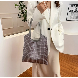 Detail of dark grey tote bag featuring sparkling rhinestone grid patterns and PU handles