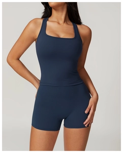 Detail view of navy blue high-waist fitness shorts and square-neck sports vest on model