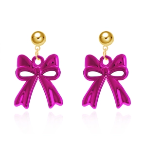 Detail of fuchsia resin bow earrings with gold-tone ball studs on a white background