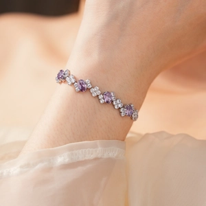 Detail of elegant silver bracelet with purple oval gemstones and white zircon on wrist