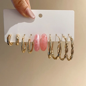 Detailed close-up of a 5-pair set of gold and pink resin hoop earrings on a display card