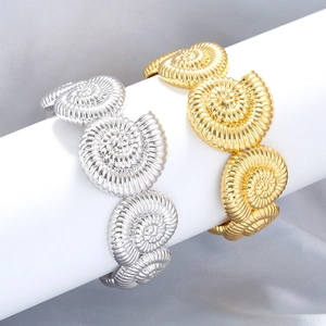 Macro shot of seashell texture spirals on gold and silver metallic fashion bracelets