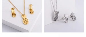 Detailed close-up of hollow out pineapple pendant and earrings set in gold and silver finish