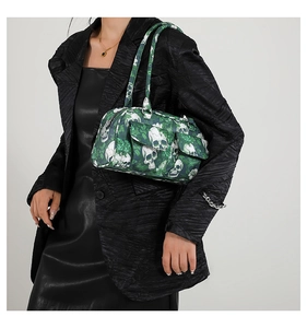 Detail of green floral and white skull print Boston bag carried by a model