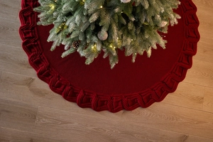 Close-up of deep red knitted Christmas tree skirt with thick cable knit border details