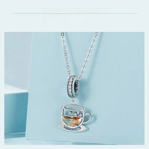 Detail view of S925 sterling silver coffee cup charm with yellow gemstone and crystals