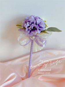 Detail of a purple silk hydrangea ball pen with lace bow and elegant pearl accents