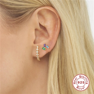 Close-up of S925 sterling silver gold earrings with colorful rectangular zircons on ear
