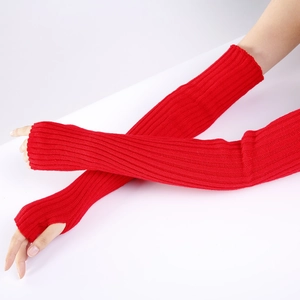Detailed close-up of vibrant red knit long fingerless gloves with functional thumb holes