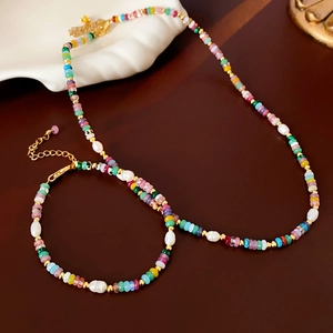 Colorful Baroque pearl jewelry set with 18K gold plated clasp on dark wood background