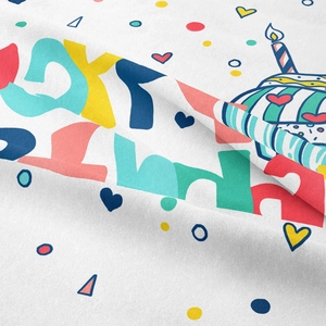 Detail of soft white fabric showing vibrant Happy Birthday print and party elements