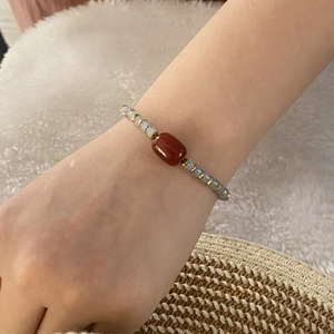 Retro natural stone beaded bracelet with red-brown cylinder beads on a white plush background