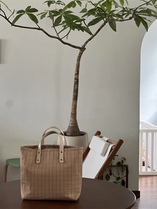 Retro plaid canvas tote bag in brown and cream gingham style on a wooden table