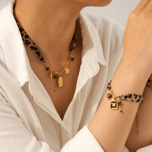 Detail of leopard print necklace and bracelet set with gold sun and heart pendants