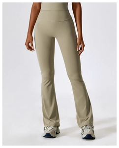 Detail of high-waisted flared yoga pants in light khaki with elastic compression fabric
