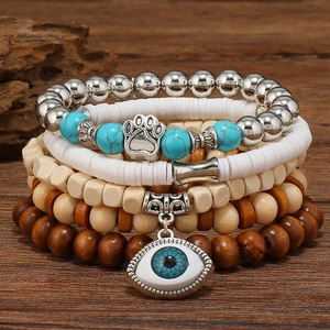 Detailed macro view of multilayer beaded bracelets with wood, metal, and evil eye charms