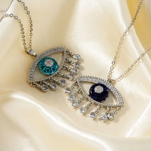 Evil eye pendant necklaces with blue cubic zirconia stones on champagne silk background