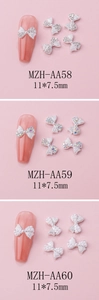 Detailed view of alloy bow nail charms with rhinestones and pearls measuring 11x7.5mm