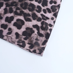 Detail view of leopard print fabric with precise double-needle stitching on the hemline