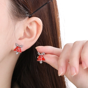 Close-up of red Christmas bell earrings with silver reindeer antlers and tiny gemstone