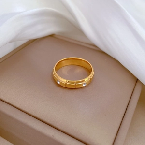 Minimalist gold geometric titanium steel ring with white crystals on a jewelry box