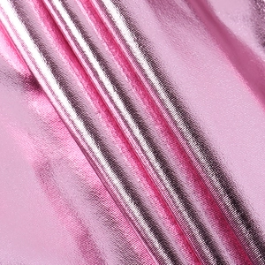 Dettaglio macro del tessuto metallizzato rosa con finitura lucida a specchio