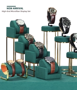Detail of dark green microfiber and gold metal frame luxury watch display set