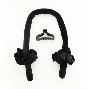Detailoverzicht van zwarte fluwelen hitteloze krulset met twee scrunchies en een grote haarklem