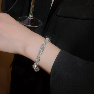 Elegant multi-layer sparkling diamond wrap bracelet on wrist with black blazer