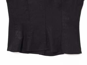 Macro view of black linen blend fabric texture and stitching detail on the garment hem