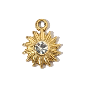 Macro shot of gold sunburst pendant with a clear gemstone center and round link