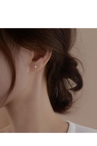 Macro view of minimalist S925 sterling silver four-pointed star stud earring with zircon