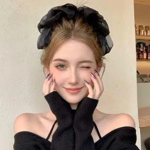 Detail of a fluffy black fabric scrunchie worn on a ponytail for a minimalist style