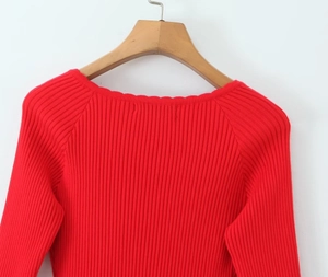 Detailed view of red ribbed knit texture and lace trim collar on a slim-fit dress