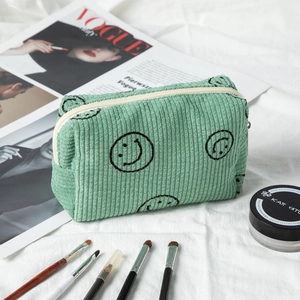 Detailed texture of mint green corduroy cosmetic bag with a cute black smiley face embroidery