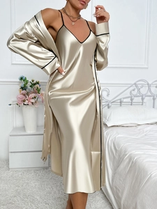 Close-up of champagne gold silk robe set with elegant black contrast piping detail