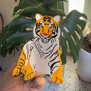 Vibrant orange acetate hair claw clip in cartoon tiger shape with high-gloss finish