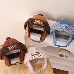 Close-up of kids' winter bear earflap hats with Lucky embroidery and plush fleece lining