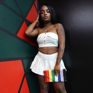 White tube top and pleated mini skirt set with rainbow clutch on colorful background