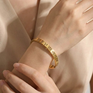 Bracelet jonc doré en acier inoxydable avec chiffres romains ajourés sur le poignet