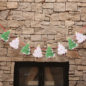 Christmas tree paper banners hanging on stone wall for festive holiday window decoration