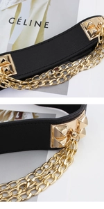 Detail of black leather elastic belt featuring gold punk chains and pyramid studs